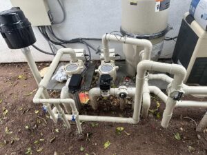 Pool equipment, such as filter, pump, motor, etc connected through pipes outside a garage.